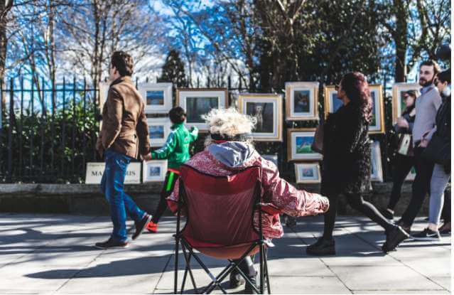 Local artist keeping an eye on her work for sale at the Sunday art market on Merrion Square